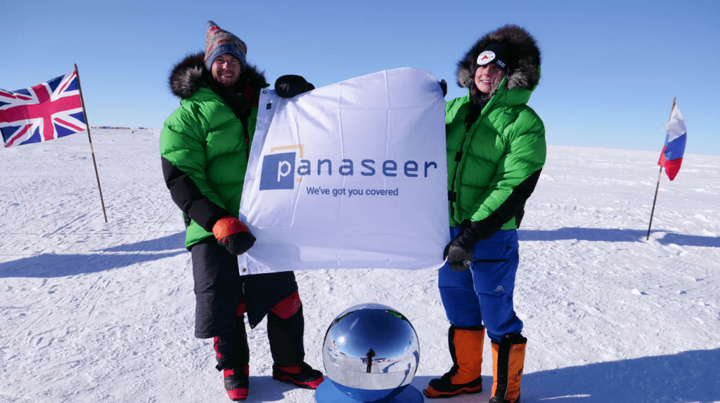 Robert Swan OBE holding the Panaseer logo on a flag at the south pole